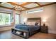 Luxurious main bedroom featuring wood beam ceiling, large windows, window seat and hardwood floors at 46 Lakes Edge Ln, Pittsboro, NC 27312