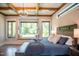 Bright main bedroom features wood beam ceiling, large windows, window seat, and natural light at 46 Lakes Edge Ln, Pittsboro, NC 27312