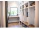 Organized mudroom with custom built-ins, bench seating, storage baskets, and a view out the window at 46 Lakes Edge Ln, Pittsboro, NC 27312