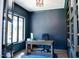 Stylish home office with dark blue walls, a wooden desk, and a large window offering plenty of natural light at 46 Lakes Edge Ln, Pittsboro, NC 27312