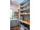 Bright pantry with gray cabinets, floating shelves, a view out the window, and a small appliance at 46 Lakes Edge Ln, Pittsboro, NC 27312