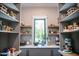 Walk-in pantry with custom shelving, ample storage space, and natural light from a window at 46 Lakes Edge Ln, Pittsboro, NC 27312