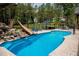 Backyard pool with a rock waterfall, slide, and ample lounge seating for relaxation and entertainment at 46 Lakes Edge Ln, Pittsboro, NC 27312