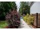 Landscaped walkway leading to a secluded pool area, enclosed by a wrought iron fence and lush greenery at 46 Lakes Edge Ln, Pittsboro, NC 27312