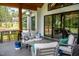 Relaxing outdoor covered porch featuring comfortable seating, stylish decor, and views of the lush backyard at 46 Lakes Edge Ln, Pittsboro, NC 27312