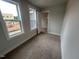 Small bedroom with carpet flooring, two large windows, and gray walls at 502 Yeowell Dr, Chapel Hill, NC 27514