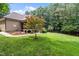 Wide backyard displaying a screened porch, wood deck, a small tree, and green grass at 512 Belmont Cir, Wake Forest, NC 27587