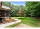 Beautiful backyard showcasing a screened porch, landscaping, and mature trees at 512 Belmont Cir, Wake Forest, NC 27587