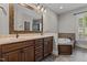 Bathroom with wooden cabinets, double sinks, large mirror, soaking tub and light fixtures at 512 Belmont Cir, Wake Forest, NC 27587