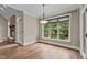 Sunlit dining area with hardwood floors, large windows overlooking deck and stone fireplace at 512 Belmont Cir, Wake Forest, NC 27587