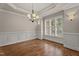 Elegant dining room showcasing wainscoting, hardwood flooring, and large windows offering ample natural light at 512 Belmont Cir, Wake Forest, NC 27587