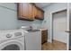 Functional laundry room with washer, dryer, overhead cabinets and utility sink at 512 Belmont Cir, Wake Forest, NC 27587