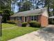 A cozy brick home featuring a covered parking area and lush, green landscaping at 520 Charlotte Ave, Rocky Mount, NC 27804