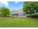 Wide view of the house from the backyard with a screened porch and a large green lawn at 532 Joe Collins Rd, Lillington, NC 27546