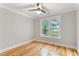 This bedroom has hardwood floors, a ceiling fan, and a window with a nice view at 532 Joe Collins Rd, Lillington, NC 27546
