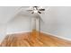 Attic bedroom features light hardwood floors, a ceiling fan, and a white door at 532 Joe Collins Rd, Lillington, NC 27546