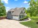 Landscaped gray home showcasing an attached garage, circular driveway, and a well-maintained lawn at 532 Joe Collins Rd, Lillington, NC 27546