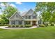 Charming two-story home featuring gray siding, black shutters, manicured landscaping, and a welcoming front porch at 532 Joe Collins Rd, Lillington, NC 27546