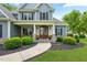 Inviting covered porch featuring a stone base, wood columns, seating, and a beautiful wood front door at 532 Joe Collins Rd, Lillington, NC 27546