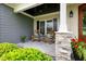 Inviting covered porch featuring a stone base, wood columns, seating, and views to the lush front yard at 532 Joe Collins Rd, Lillington, NC 27546
