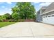 Exterior shot of the garage of the house with a wide concrete parking pad and green lawn at 532 Joe Collins Rd, Lillington, NC 27546