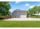 Exterior shot of the garage of the house with a wide concrete parking pad and green lawn at 532 Joe Collins Rd, Lillington, NC 27546