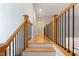 Bright hallway features beautiful wood floors, stairs, and railing with dark metal accents at 532 Joe Collins Rd, Lillington, NC 27546