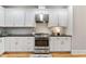 Modern kitchen with stainless steel appliances, black countertops, and white cabinets at 532 Joe Collins Rd, Lillington, NC 27546