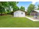 Exterior shot of the shed in the backyard with a white door, green grass, and dog kennel at 532 Joe Collins Rd, Lillington, NC 27546