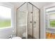 Corner shower with glass door, tile surround, and natural light from the adjacent window at 532 Joe Collins Rd, Lillington, NC 27546