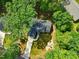 Stunning aerial view of a home surrounded by lush greenery, showcasing its serene and private setting with a driveway at 6102 Burning Tree Cir, Sanford, NC 27332