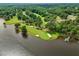 Scenic aerial view of a golf course along a lakefront with lush green fairways and pristine sand bunkers at 6102 Burning Tree Cir, Sanford, NC 27332