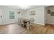 Cozy dining room featuring a wooden table with white chairs, modern light fixture, and decorative wall art at 6102 Burning Tree Cir, Sanford, NC 27332