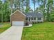 Charming single-story home featuring a stone facade, attached garage, and well-manicured lawn at 6102 Burning Tree Cir, Sanford, NC 27332