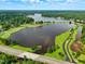 Expansive aerial view featuring a scenic lake, golf course, and lush green surroundings under a partly cloudy sky at 6102 Burning Tree Cir, Sanford, NC 27332
