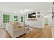 Bright living room featuring modern finishes, hardwood floors, large windows, and neutral-toned furnishings at 6102 Burning Tree Cir, Sanford, NC 27332
