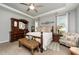 Comfortable bedroom with a tray ceiling, a wooden bed frame, a dresser, and a cozy armchair at 71 Sanibel St, Clayton, NC 27520