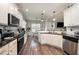 Bright kitchen featuring white cabinetry, granite countertops, stainless steel appliances, and a dining area at 71 Sanibel St, Clayton, NC 27520