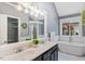 Bright bathroom featuring a dual sink vanity, soaking tub, and natural light at 7132 Deer Brook St, Willow Springs, NC 27592