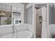 Well-lit bathroom featuring a soaking tub and tiled walk-in shower at 7132 Deer Brook St, Willow Springs, NC 27592