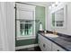 Bathroom with marble counters, under cabinet storage, vanity lighting, and window at 7132 Deer Brook St, Willow Springs, NC 27592
