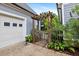 A quaint garden with small wooden fence sits next to the garage door with green foliage at 7132 Deer Brook St, Willow Springs, NC 27592