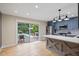 Open kitchen with stainless steel appliances, stylish cabinetry, and a view of the backyard pool and deck at 7132 Deer Brook St, Willow Springs, NC 27592
