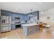 Modern kitchen featuring stainless steel appliances, custom blue cabinetry, and an island, perfect for cooking and dining at 7132 Deer Brook St, Willow Springs, NC 27592
