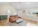 Bright living room featuring vaulted ceilings, recessed lights, a leather sofa, and large windows at 7132 Deer Brook St, Willow Springs, NC 27592