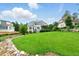 Large, well-manicured backyard showcasing lush lawn and professional landscaping with water feature at 77 Ruffed Grouse, Chapel Hill, NC 27517