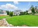 Expansive backyard featuring a well-manicured lawn, lush landscaping, and mature shade trees at 77 Ruffed Grouse, Chapel Hill, NC 27517