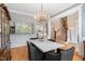 Bright dining area features an ornate chandelier, a stone-top table, and a view into other parts of the house at 77 Ruffed Grouse, Chapel Hill, NC 27517