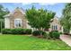 Charming home exterior with a stone facade, manicured lawn, and mature landscaping, showcasing its curb appeal at 77 Ruffed Grouse, Chapel Hill, NC 27517