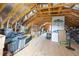 Unfinished attic featuring exposed rafters, a window for light, insulation, and ample storage area at 81 Dot Ct, Fuquay Varina, NC 27526